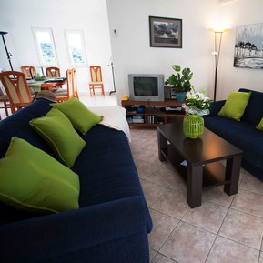 photo of view from arc rentals properties with a seaview in split croatia from an apartment rental on ciovo with a terrace and balcony with sunloungers blue couches tv green pillows and cream throw
