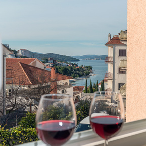 photo of view from arc rentals properties with a seaview in split croatia from an apartment rental on ciovo with two glasses of red wine and seaview