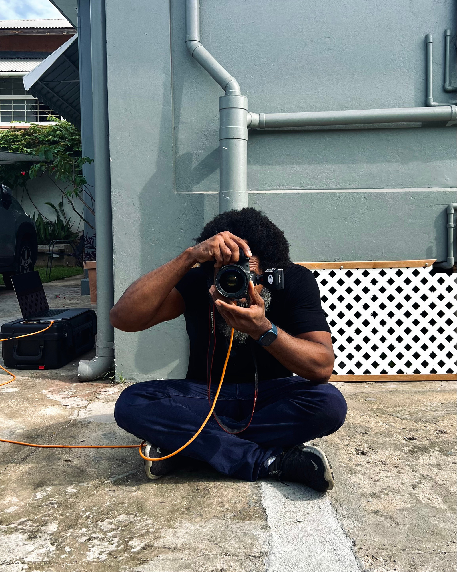 Portrait of Marlon James with camera and laptop in the background. 