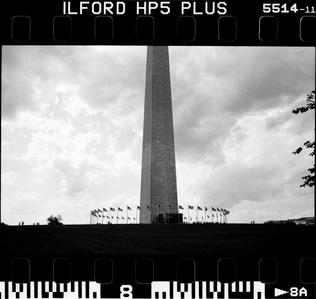 A black and white picture taken on film of the washingon monument. 