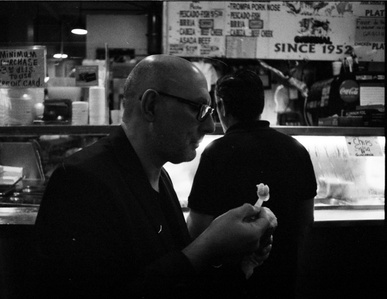 Street photography of a man eating his ice cream in Los Angelas grand central market. 