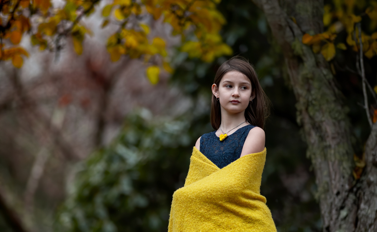 Jacqueline wrapped in a yellow shawl and wearing a blue gown with yellow Hearts and Roses necklace shot by Nigel Sloley Photography.
