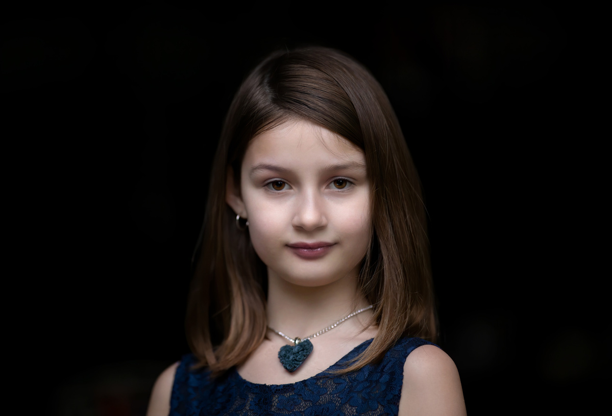 Portrait of Jacqueline wearing a blue gown and blue Hearts and Roses necklace, jewelry shot by Nigel Sloley Photography.