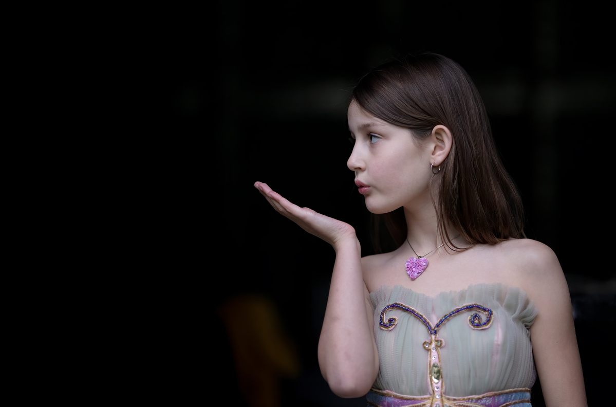 Portrait of Jacqueline wearing a mauve Hearts and Roses necklace, blowing a kiss, jewelry shot by Nigel Sloley Photography.
