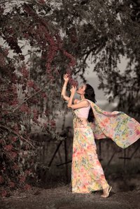 girl in the farm standing under a tree smeling fragnance from flowers shot best advertising photographer in santacruz east mumbai and pune india
