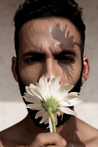 male model smelling white flower shoot by best Indian fashion photographer based in pune india
