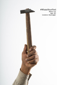 a carpenter proudly holds up a hammer as his tool of pride for a concept photography series shoot by best indian advertising photographer based in mumbai india