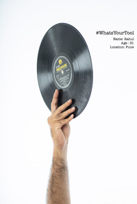 A disc jokey holding up an antique disc as his tool of choice for a conceptual photography shoot by best indian fashion and advertising photographer based in mumbai india