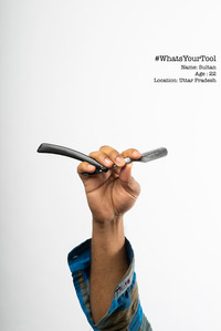 a barber holds up his classic old indian blade ustra used to shave as his tool of choice photoshoot by leading indian conceptual photographer based in santacruz mumbai