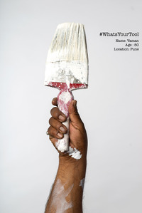 a painter holds up his paint brush as his tool of choice for his profession photoshoot by best commercial photographer based in bombay
