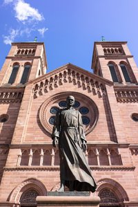 A tall statue standing in the front of the entrance of a building shot at noo by Ashish Gurbani best travel photographer based in Mumbai India.