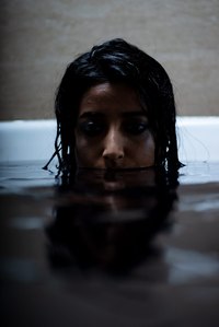 female model depressed sitting in the tub filled with black water photography concept by leading indian fashion photographer based in santacruz mumbai