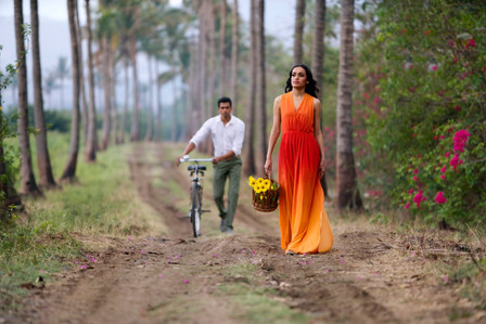girl wearing orange designer gown walking the farmlands concept shoot by best advertising photographer based in mumbai
