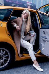 a portrait photograph professionally taken of a female model sitting sideways in a yellow taxi with its door open her legs out shot by leading advertising photographer ashish gurbani based in pune india