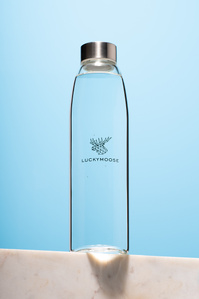 a water bottle shot on a marble slate in front of a sky blue background shot by best luxury product photographer in Bangalore