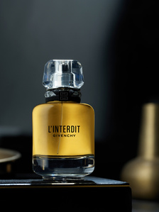 a golden glowing perfume bottle placed of a luxury leather tray photographed in a studio lighting photographed by best commercial photography studio near me