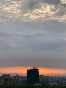 a photograph of a daily sunset with a cloudy sky in front of a construction site stopped work due to covid 19 shot by leading outdoor photographer ashish gurbani based in Mumbai india