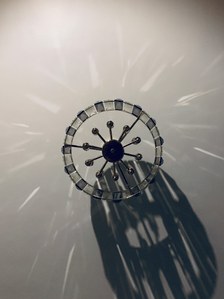a top down view of a black chandelier hanging from a white ceiling with specks of its light on the ceiling shot during quarantine by best product photographer ashish gurbani based in Mumbai india