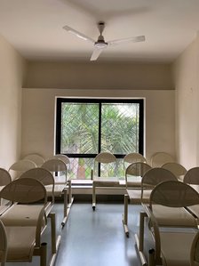 photograph of a visit to a empty hospital during quarantine with a window, fan and empty white chairs in frame shot by best advertising photographer ashish gurbani based in Mumbai india