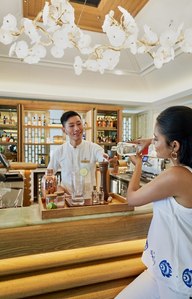 a lady preparing bar cocktails with St Regis bartender for branding photography by leading commercial studio near me