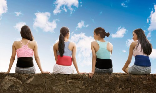 4 girls sitting on a wall with heating belts photoshoot by best indian advertising photographer based in pune
