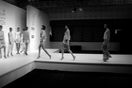 a candid blurred black and white photograph of female models on a ramp taken in a dark set up with light on the stage professionally shot by best fashion photographer ashish gurbani based in pune india