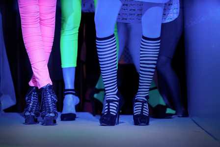 a candid shot of the legs of female models in heels and neon clothing in an indoor setting professionally taken by best fashion photographer ashish gurbani based in pune india