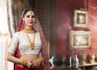 modern Indian bride in a white blouse wearing gold authentic Maharashtrian jewelry posing for a photo of jewelry collection in a studio setup using studio equipment shot by best jewelry campaign photographer based in Pune