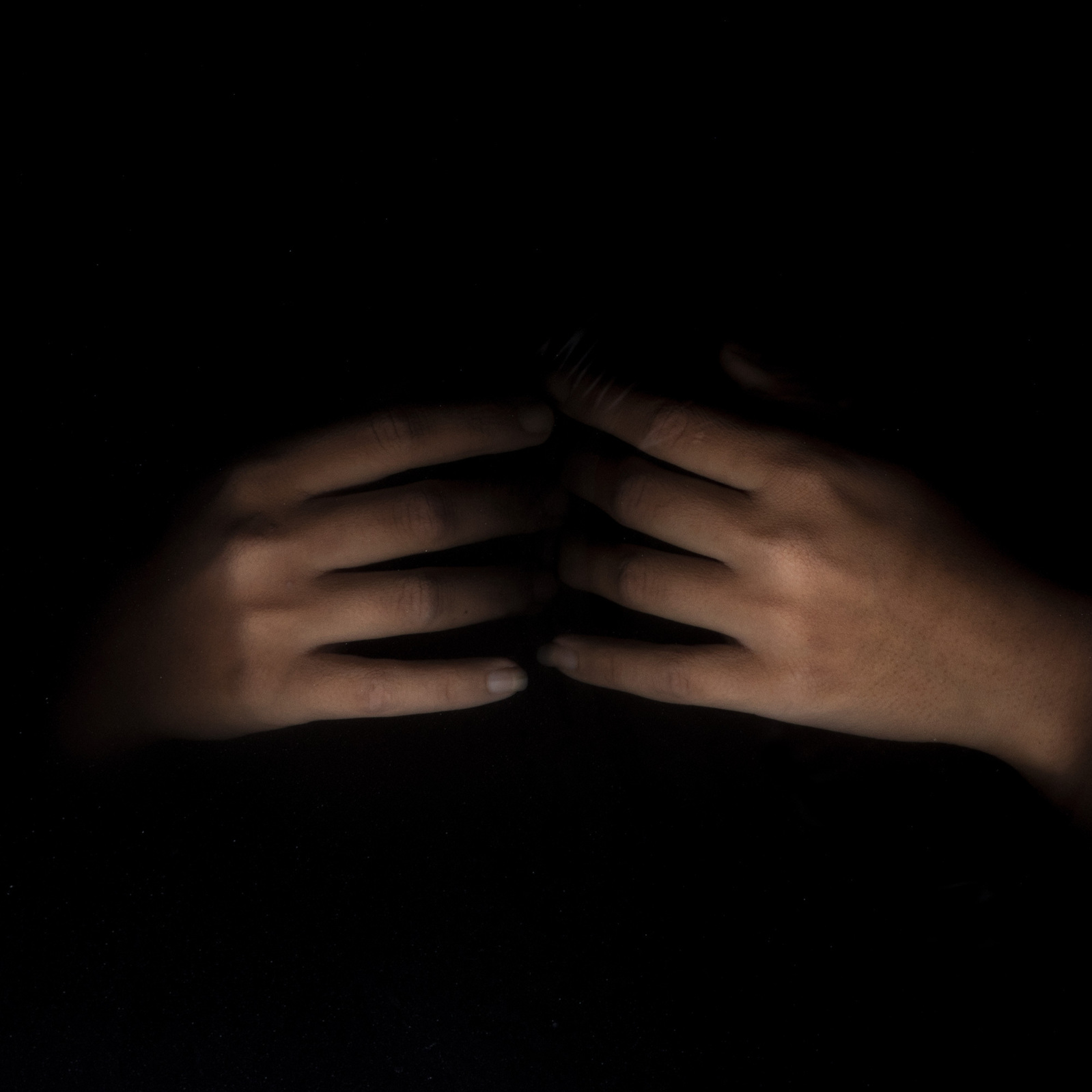 fading away hands of girl suffering from anxiety and depression in black water photograph by top conceptual photographer in india