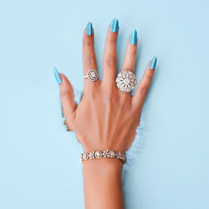 a minimalistic concept splash in coloured liquid of a hand and jewellery on it professionally photographed for best jewellery brand shoot by leading jewellery photographer based in mumbai india