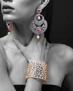 a female model wearing stunning gold and diamond jewellery on a black background sho tby the best jewellery photographer based in pune