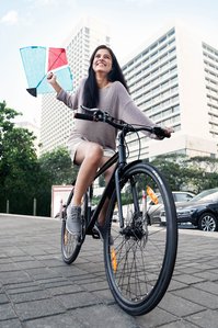 A young girl having fun riding her cycle with a kite at mumbai marine drive for a cycle tire brand shoot by leading commercial photographer based in Mumbai India.
