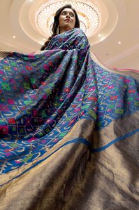 best indian model wearing blue peacock colour embroidered saree flowing away by best authentic saree brand Kasat saree concept shoot by top indian advertising photographer based in mumbai india