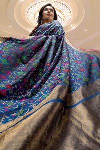 best indian model wearing blue peacock colour embroidered saree flowing away by best authentic saree brand Kasat saree concept shoot by top indian advertising photographer based in mumbai india
