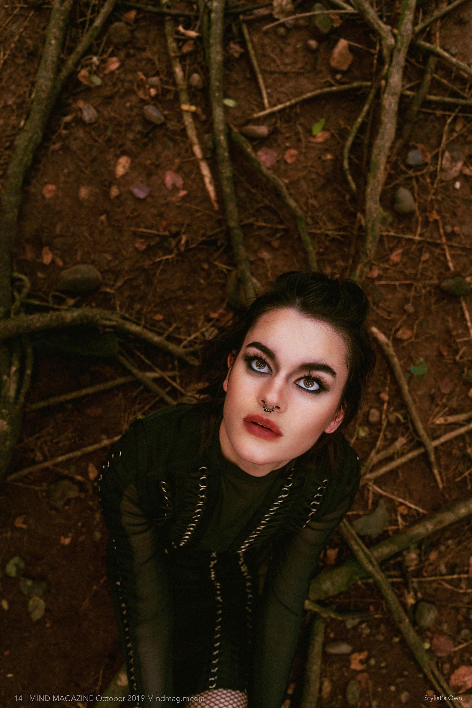 Melissandre posing as a witch sitting on her knees inside a forest shot upside down by best fashion photographer based in Mumbai India.