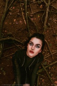 Melissandre posing as a witch sitting on her knees inside a forest shot upside down by best fashion photographer based in Mumbai India.