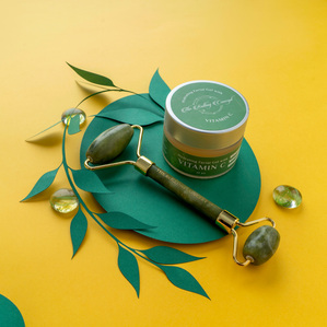 green vitamin C gel and jade face roller products on a conceptual chart paper setup photoshoot with flash lighting in a studio for the rolling concept brand campaign by best cosmetic photographer based in mumbai india