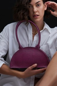 A model is endorsing this wine red plant-based bank while focussing on the camera