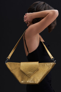 a golden bag held by a fashion model in a studio lighting setup in a photoshoot with one of indias best luxury product photographer based in mumbai india