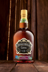 a beatiful Chivas 13 year old rare whiskey shot on wooden planks by conceptual luxury product photographer specialising in beverage photography based in pune india