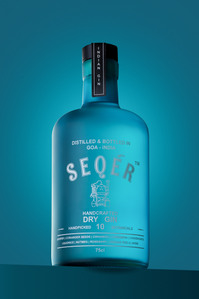 concept-based photoshoot for the amazing seqer gin Indian gin brand on a sky blue set background in a studio setup photographed by the best alcohol brand photographer based in mumbai india