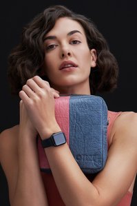 A blue plant-based leather bag being held by a beautiful model in a studio lighting set up for brands Photoshoot by best luxury photographer based in Pune India