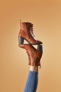 a pair of brown boots worn upside down by a trending model for a footwear branding photography by leading photo studio in pune india
