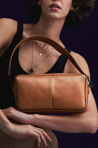 a female models holding a beautiful tan coloured plant-based handbag for a fashion brand campaign photography shoot by leading bag photographer based in pune india