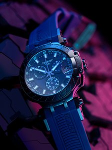 A luxury tissot watch placed on a rubber tire with coloured lighting photographed for a branding campaign shoot