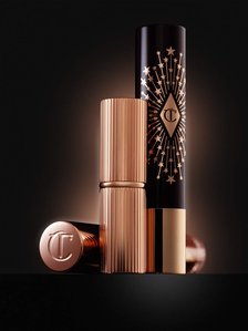 a creative image of golden lipstick and cosmetics shades photographed by creative product photographers near me