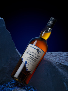 a bottle of single malt whiskey photographed on rocks in midnight blue studio lighting photographed by creative product photographer based in pune