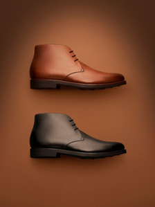 formal leather shoes lying down on a tan brown background photographed by leading commercial footwear photographr