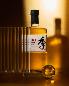 a beautiful sunset with product photography services with a golden background concept bottle of whiskey toki in mumbai india