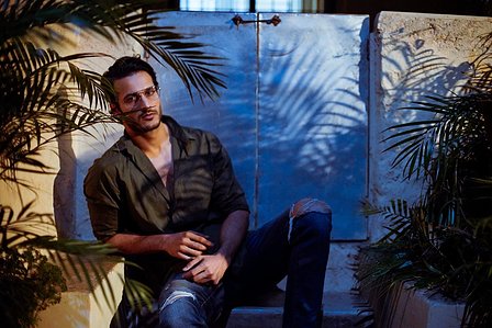 model angel singh posing for a fashion photoshoot in an outdoor set up with shadows of plants all around in abstract manner photoshoot with best garment photographer ashish gurbani based in mumbai india